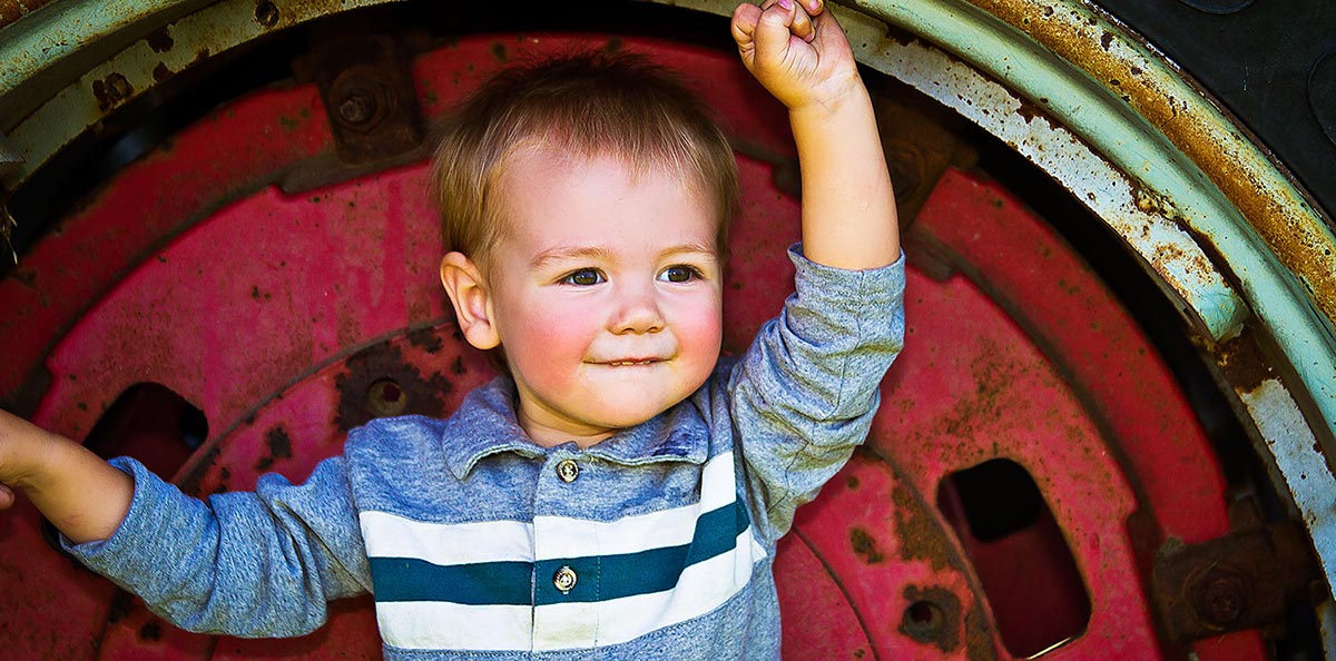 Photo of a Happy Child in an old Farm Tractor Tire, Peoria, IL